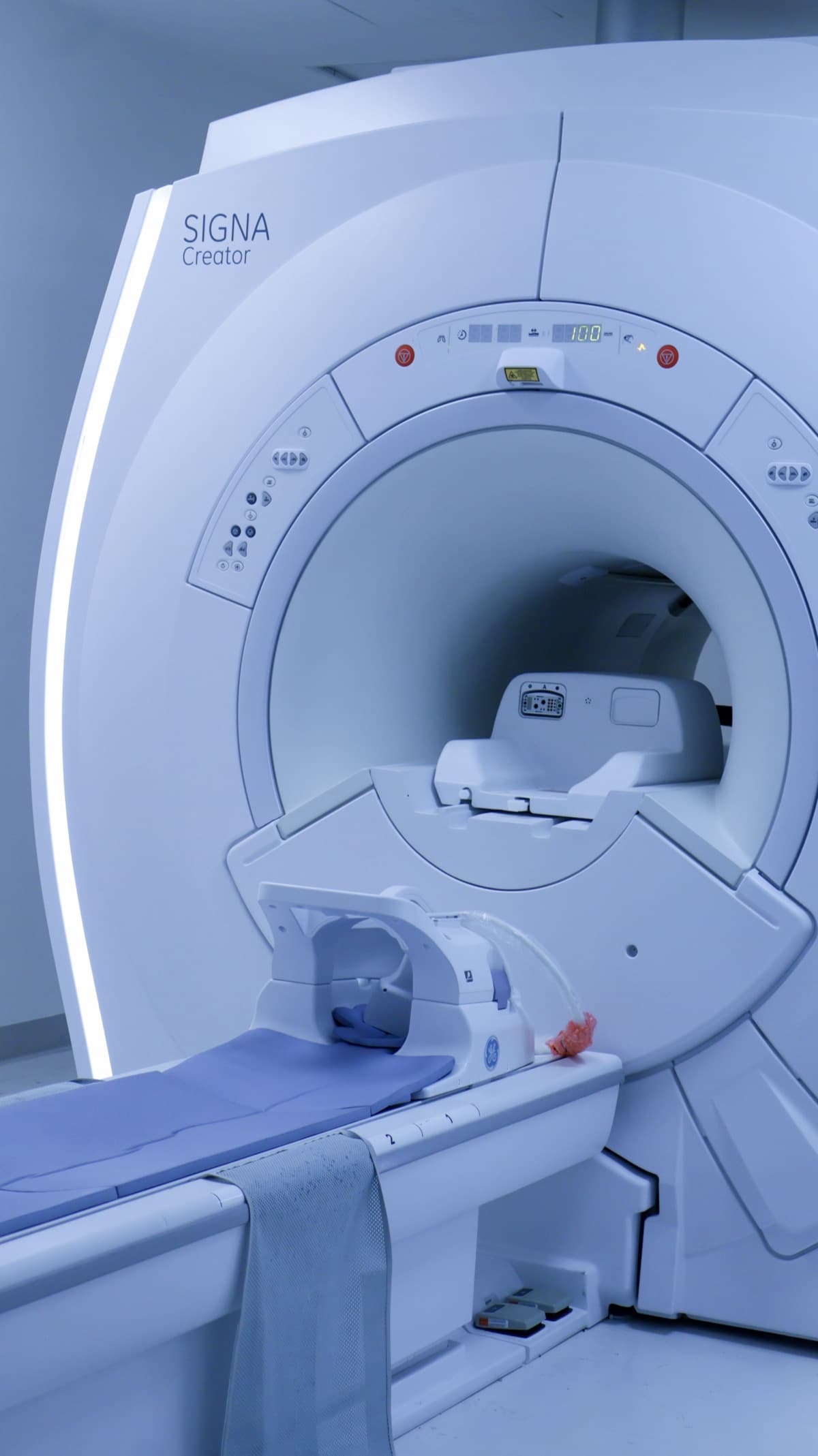 MRI scanner seen head-on with the table and head coil positioned at the bore